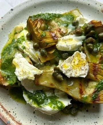 Grilled artichokes served with wild garlic salsa verde and mozzarella on a plate