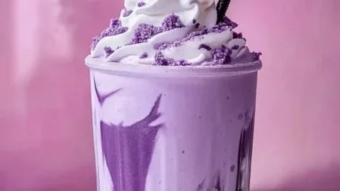 Delicious creamy ube milkshake topped with whipped cream and colorful sprinkles
