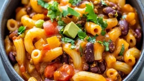 Delicious bowl of hearty vegetarian chili mac topped with fresh herbs.