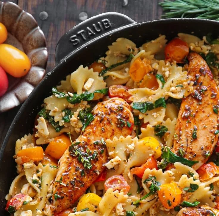Creamy Chicken Feta Pasta garnished with herbs and vegetables