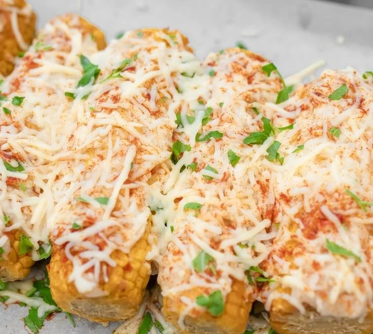 Delicious Mexican Street Corn with chili, cheese, and lime served on a cob.