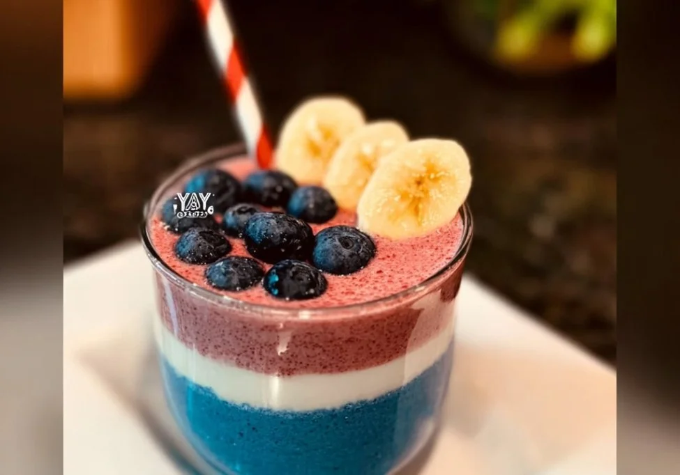 Red White and Blue Smoothie with strawberries, blueberries, and yogurt in a glass